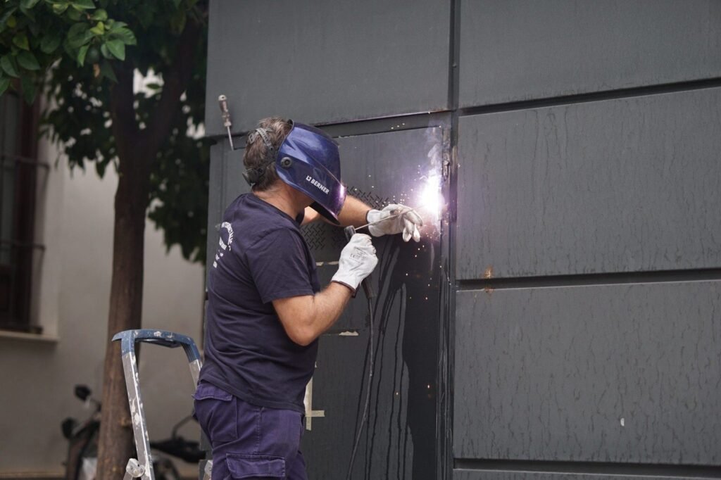 Soldador com equipamento de proteção trabalhando em peça metálica (foto ilustrativa)